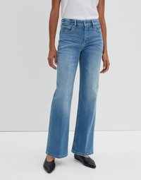 Light blue denim wide-leg jeans with a high waist, front pockets, and faded details. Paired with black pointed-toe shoes.