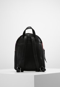 Czarny skórzany plecak z zaokrąglonym wierzchem, podwójnymi szelkami, małą przednią kieszenią i kolorowymi akcentami po bokach. Gładka faktura.