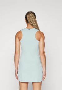 Svetlo modra brezrokavna obleka s prilegajočim se dizajnom, rebrasto teksturo in majhnim črnim črtastim poudarkom na hrbtni obleki.