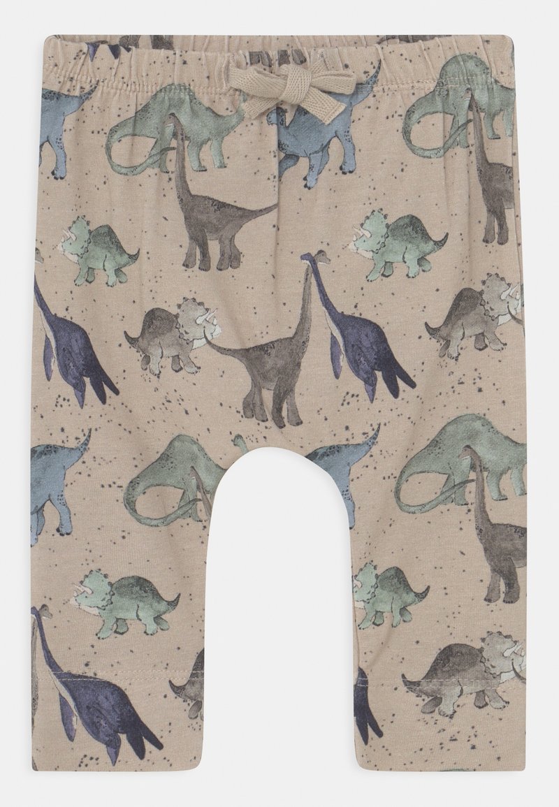 Leggings beige avec un imprimé de dinosaures représentant plusieurs dinosaures en vert, bleu et violet. Taille élastique avec un détail nœud.