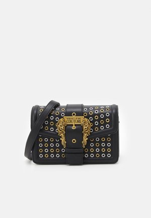 Schwarze rechteckige Lederschultertasche mit goldenen und silbernen Ösen, einer goldenen verzierten Schnalle und dem Etikett "Versace Jeans Couture".
