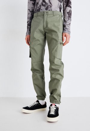 Pantalones cargo en verde oliva, fabricados con un tejido duradero. Cuentan con bolsillos laterales con cremallera, tobillos ajustados y una cinturilla elástica.