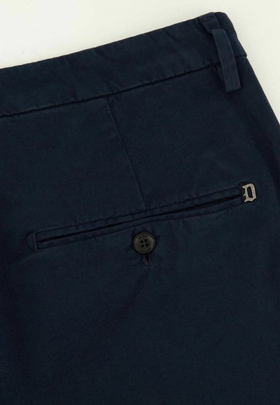 Pantalon bleu marine avec une poche arrière dotée d'une fermeture à bouton noir et d'un accent décoratif en forme de D près de la poche. Tissu texturé.
