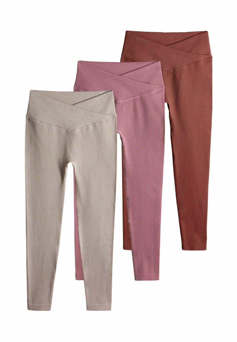 Tre par ribbade leggings i beige, rosa och rostfärg, med en bred, korsad midjeband och elastisk tyg för komfort.