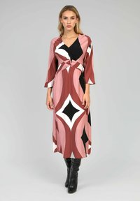 Robe longue à motifs avec un décolleté en V, un détail noué à la taille et des manches trois-quarts. Les couleurs comprennent le rose, le noir et le blanc.