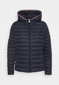 Veste matelassée bleu marine avec capuche, fermeture éclair intégrale à l'avant, poches latérales et petit logo sur la poitrine.