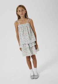 Ljusblå sommarklänning med blommigt mönster, med en smockad bustier och två lager av volanger. Justerbara axelremmar.
