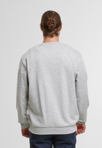 Grau Sweatshirt mit rundem Halsausschnitt und gerippten Bündchen, mit weichem Fleece-Touch und lockerer Passform, von hinten gezeigt.