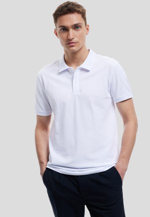 Witte polo shirt van een soepele stof met een klassieke kraag en twee knopen, voorzien van korte mouwen en subtiele textuuraccenten.