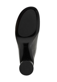 Zapato de tacón alto negro con un exterior de cuero suave, puntera redondeada y suela de goma antideslizante con estrías horizontales para mayor tracción.