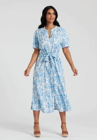Jasnoniebieska midi sukienka w kwiaty z krótkimi rękawami, paskiem wiązanym w talii oraz dekoltem w kształcie litery V. Materiał ma miękką teksturę i zwiewny krój.
