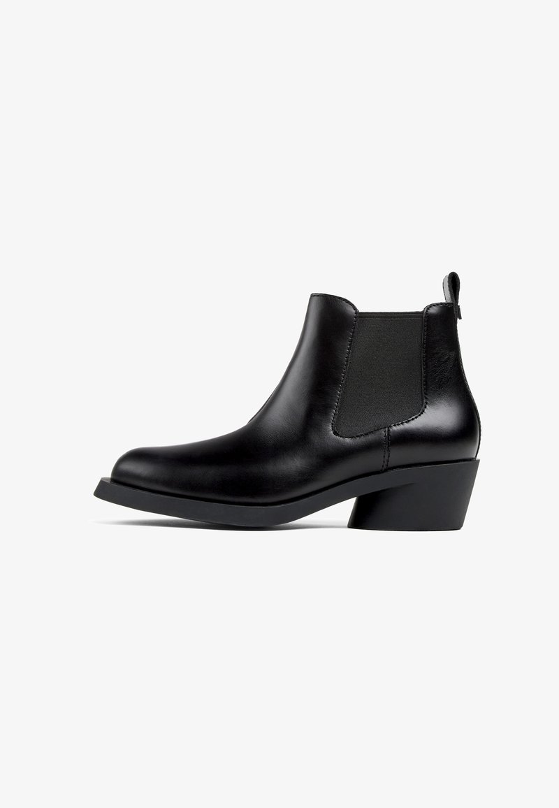 Czarne skórzane botki za kostkę z elastycznymi panelami bocznymi, o zaokrąglonym nosku i niskim, zdobionym obcasie. Gładka tekstura z minimalnymi detalami przeszyć.