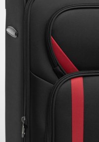 Zwarte koffer met een gestructureerd oppervlak, voorzien van een rode acccent en een contrasterende zwarte streep. Ritsdetails zichtbaar aan de zijkant.