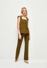 Olijfgroen pak met een getailleerde mouwloze top met vierkante halslijn, vijf knopen en bijpassende rechte broek.