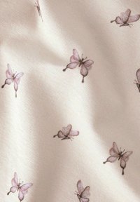 Tejido de algodón con un fondo crema claro y un patrón repetido de pequeñas y delicadas mariposas rosas con un sutil detalle marrón.