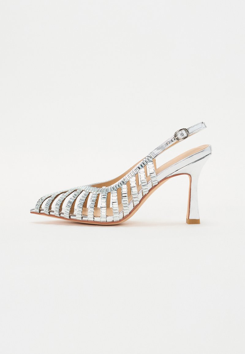 Scarpa silver con tacco alto e cinturini, dalla punta affilata e design aperto, caratterizzata da dettagli metallici e un cinturino dietro. Texture liscia.