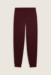 Pantaloni della tuta bordeaux con una consistenza morbida, vita elasticizzata e polsini affusolati. Due tasche laterali discrete vicino alla vita.