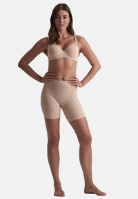 Naadloze huidkleurige bh en shorts tot halverwege de dij in een soepele, rekbare stof. Voorzien van een gevormde cupontwerp en minimale hardware voor extra comfort.