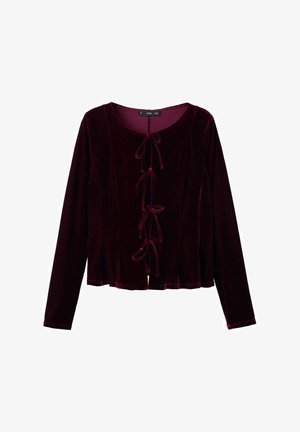 Bordo plišani top s dugim rukavima, okruglim izrezom i dekorativnim vezanjem sprijeda. Mekana tekstura i lepršavi dizajn.