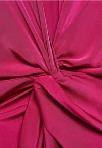 Tessuto di satin fucsia drape e annodato, con una texture liscia e lucida, con pieghe che creano profondità e un aspetto dinamico.