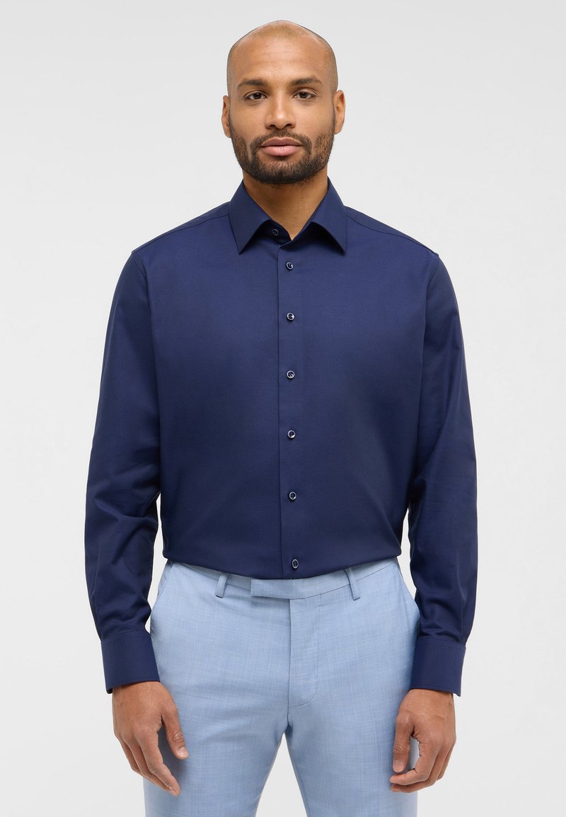 Marineblaue Langarmshirt mit glatter Textur, Knopfleiste vorne und passenden Knöpfen. Es hat einen klassischen Kragen und eine taillierte Passform.