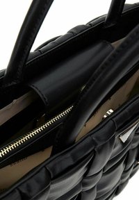 Sac à main en cuir noir avec un design tressé, des poignées doubles et une fermeture éclair. Doublure intérieure de couleur claire avec un motif subtil.