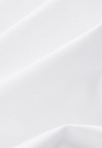 Tessuto bianco, liscio e con una leggera lucentezza, che mostra pieghe morbide e texture diverse, evidenziando la sua morbidezza e una consistenza di colore uniforme.