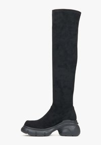 Černé kozačky nad kolena vyrobené z měkké semišové kůže, s kulatou špičkou a masivní černou gumovou podrážkou, s bezšvým designem a minimálním prošíváním.