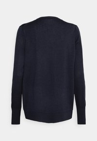 Pull bleu marine à manches longues, col rond, avec des poignets et un ourlet côtelés. Fabriqué en matériau tricoté doux, présentant une texture subtile.