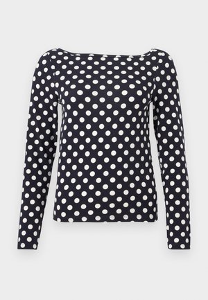 Chemise bleu marine à manches longues avec des pois blancs, encolure bateau et coupe ajustée.