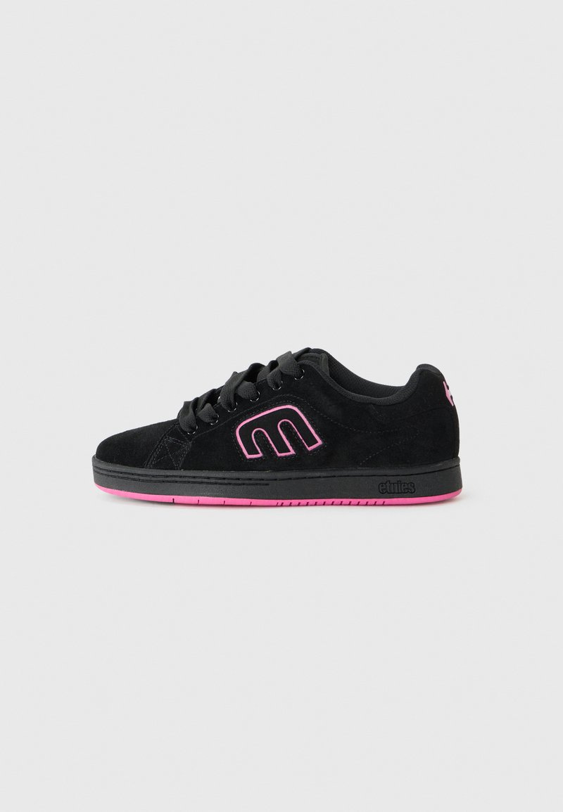 Juodos suede sportbačiai su rožinėmis detalėmis, su raiščiais ir logotipu šone, ant vientiso balto fono.