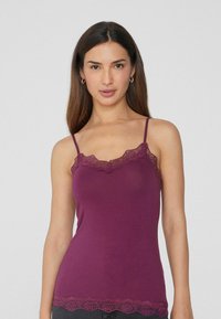 Camiseta de tirantes burdeos con tirantes ajustables, ribete de encaje en el escote y el dobladillo, con una textura de tela suave y un corte ajustado.