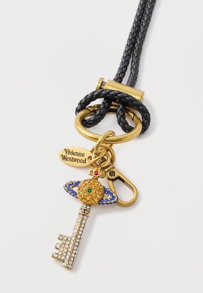 Zlatni privezak za ključeve s ukrasnim ključem ukrašenim šarenim cirkonima, pričvršćen na ispleteni crni remen i metalni kopču, označen oznakom "Vivienne Westwood".