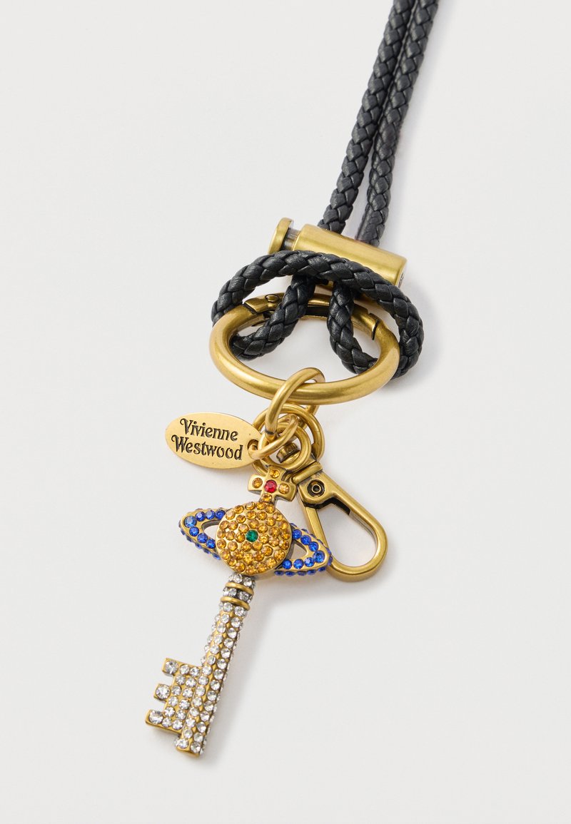 Guld nøglering med en dekorativ nøgle med farverige rhinsten, fastgjort til en flettet sort rem og en metallisk lås, mærket "Vivienne Westwood."