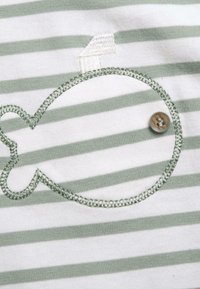 Katoenen shirt met horizontale groene en witte strepen, voorzien van een geborduurd walvisontwerp en een kleine knoopaccent.