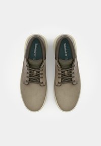 Bruine leren schoenen met een gladde textuur, voorzien van ronde neuzen, een traditionele vetersluiting en contrasterende lichte rubberen zolen.