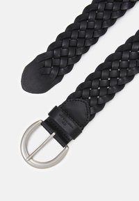 Cinturón de cuero trenzado negro con una hebilla de metal plateado. Presenta extremos de cuero lisos y una textura intrincada entrelazada en toda su superficie.