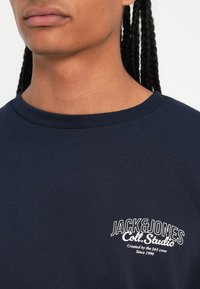 Marine crewneck sweatshirt laget av bomullsblanding, med hvit brodert logo på brystet og ribbestrikket hals. Myk tekstur, uformell design.