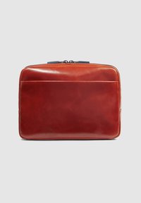 Borsa rossa in pelle con una superficie liscia, forma rettangolare, tasca frontale e chiusura a cerniera superiore. Accentuata da un tirante della cerniera blu.