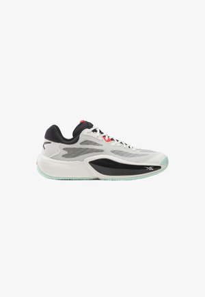 Schmal geschnittener Sportschuh mit weißem Mesh-Obermaterial, schwarzen Akzenten, mintgrüner Sohle und roten Schnürösen, seitlich dargestellt.