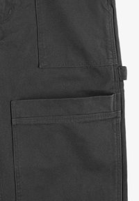 Ciemnoszare spodnie cargo z dwiema dużymi kieszeniami z przodu, wykonane z trwałego materiału, z przeszyciami i prostym krojem.