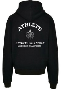 Sudadera con capucha negra que presenta texto blanco en la parte trasera: "ATLETA", "TEMPORADA DEPORTIVA" y "HECHA PARA CAMPEONES" con acentos decorativos.