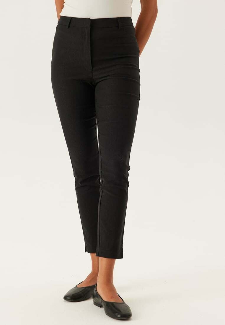 Pantaloni neri a vita alta con una vestibilità slim, caratterizzati da una texture liscia e un design a gamba dritta. Nessun motivo visibile o hardware.
