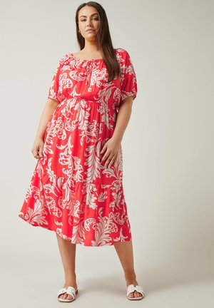 Rode bloemrijke maxi-jurk met korte pofmouwen, elastische taille en gelaagde rok. Heeft grote witte bladvormen.