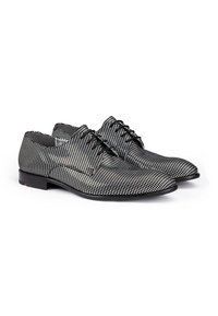 Chaussures habillées à motifs noir et blanc avec un bout arrondi, une texture lisse, un design à lacets et un petit talon.