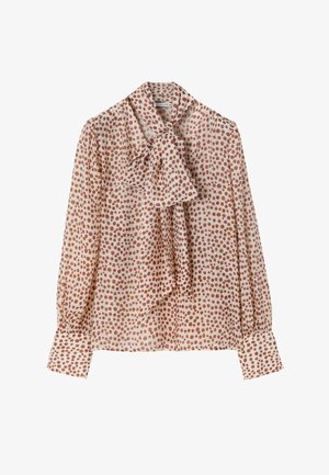 Beige blouse met lange mouwen en roestkleurige stippen, voorzien van een grote strik bij de kraag en brede manchetten.