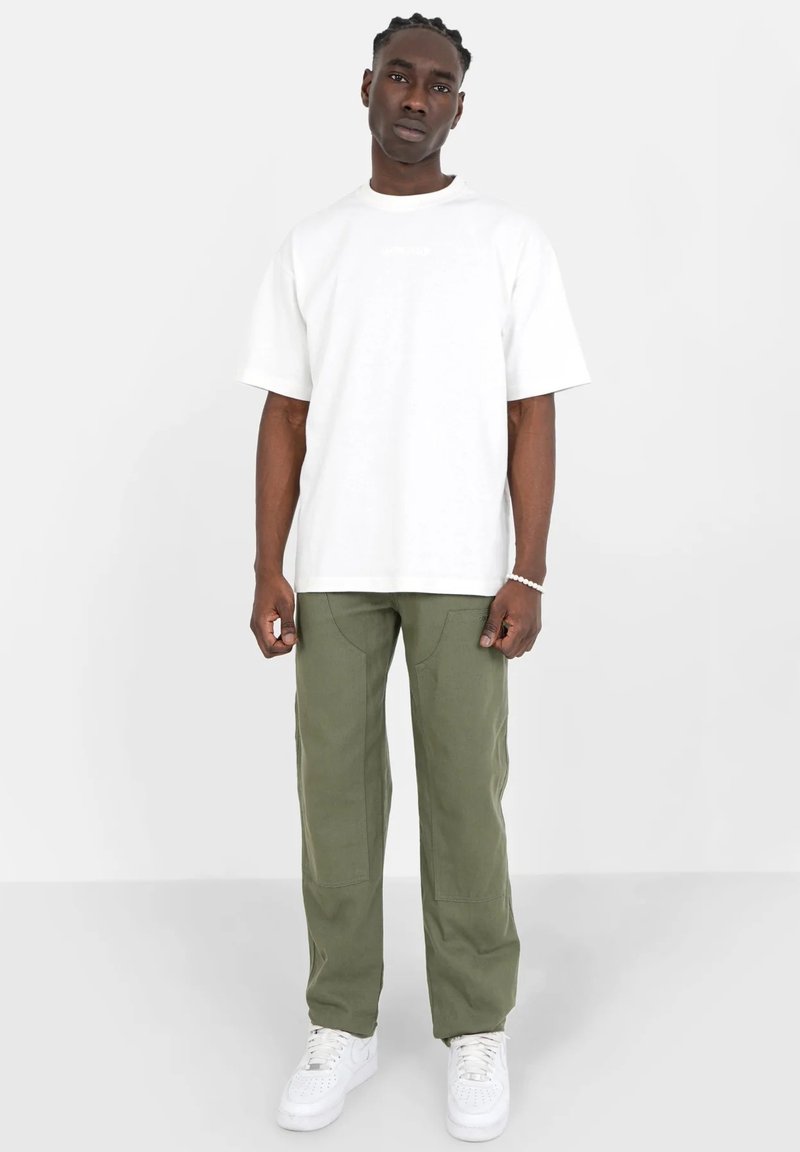 Hvid bomulds T-shirt med rund hals, parret med grønne cargo bukser med frontlommer og lige ben design, afsluttet med hvide sneakers.