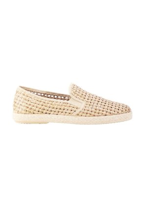 Zapato deportivo de color beige claro tejido, sin cordones, con suela plana y diseño abierto y transpirable, mostrado de lado sobre un fondo blanco.