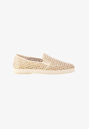 Zapato deportivo de color beige claro tejido, sin cordones, con suela plana y diseño abierto y transpirable, mostrado de lado sobre un fondo blanco.