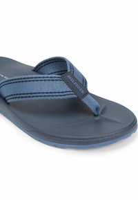 Herre blå klipklapper med en tekstureret sål og stofremme med kontrasterende striber. Logodetalje på remmen. Casual design.